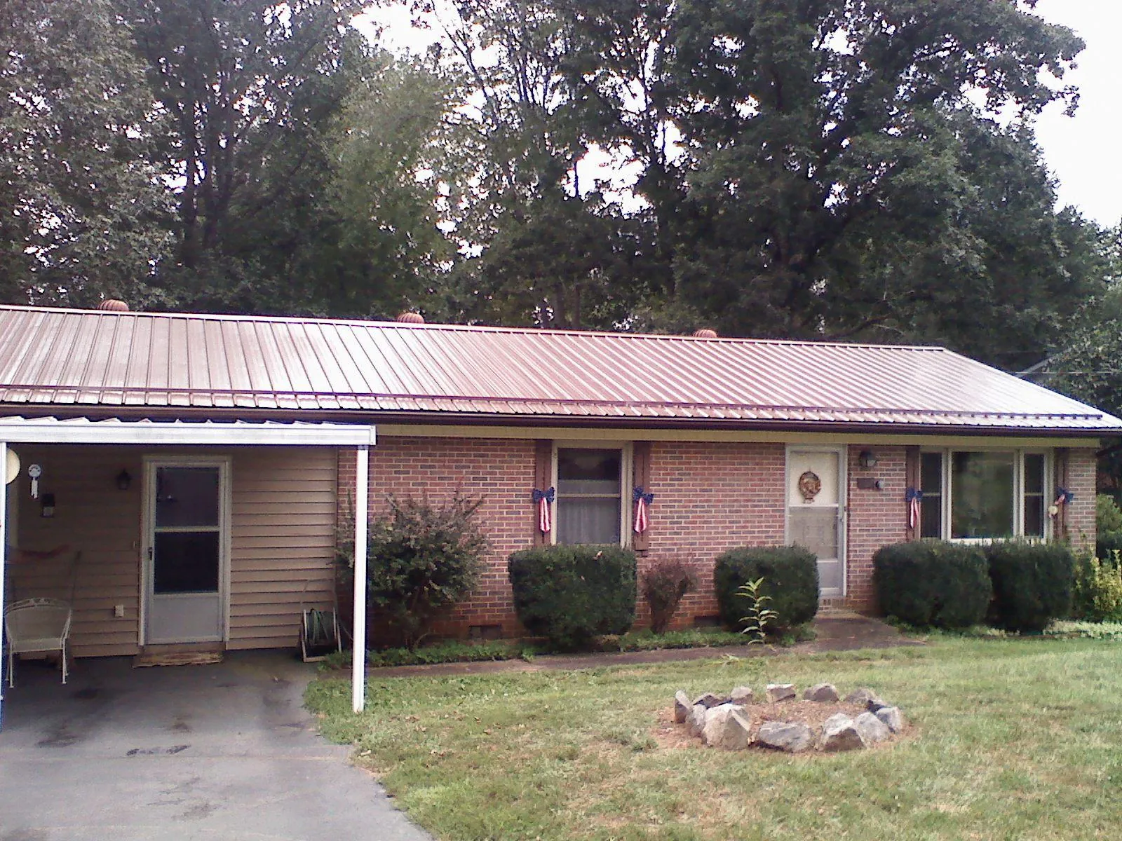 Bronze metal roof and carport on a brick ranch home — Roof Repair work by our crew in Tyner