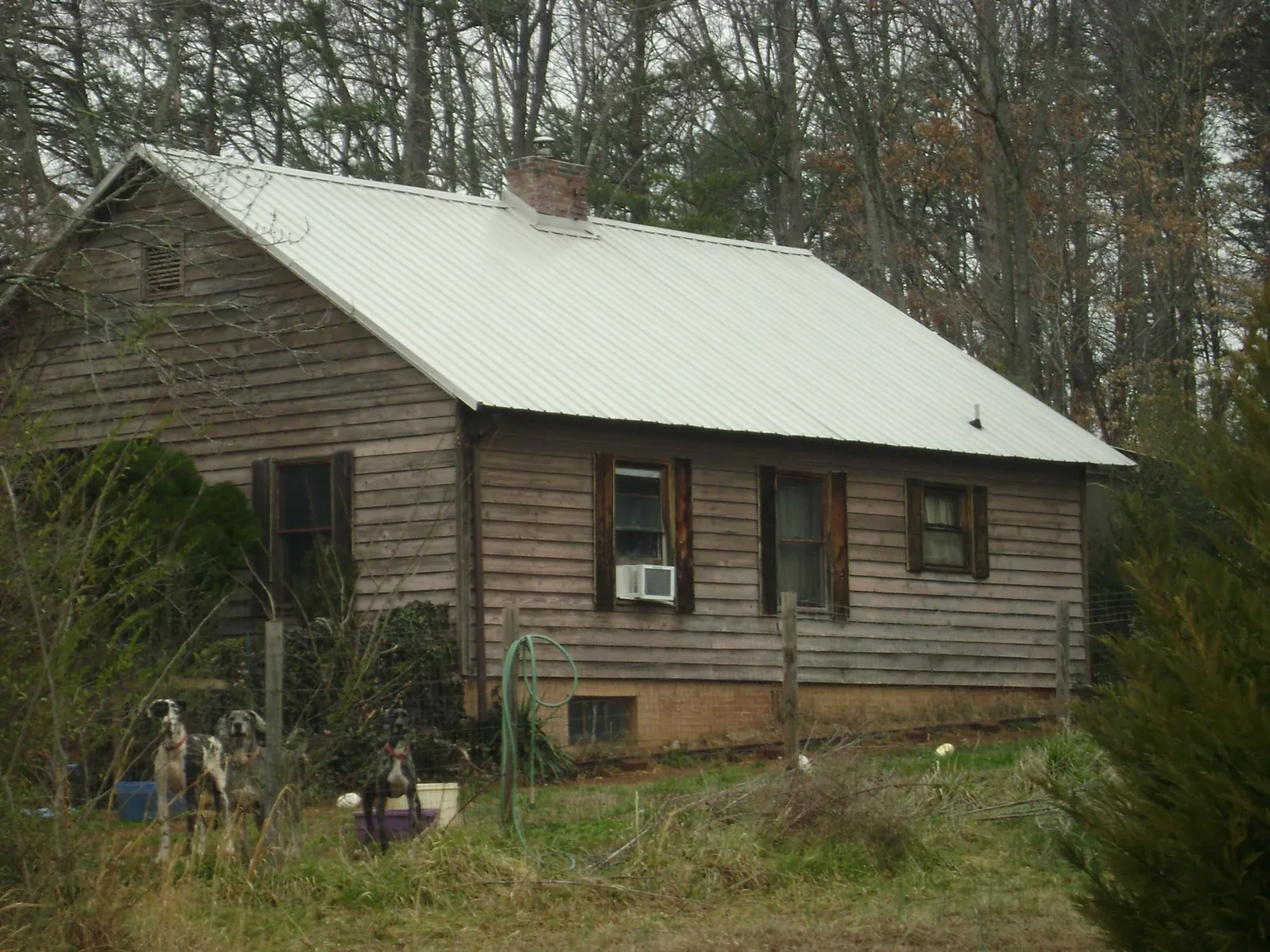 White metal roof on an old wood sided farmhouse, from a Metal Roof Installation job in Tyner